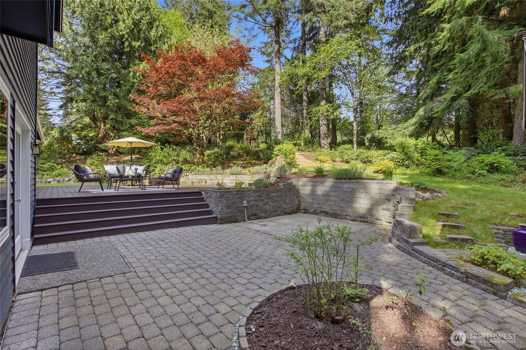 Pacific Northwest dream home featuring lush landscaping, mature trees, and private outdoor living