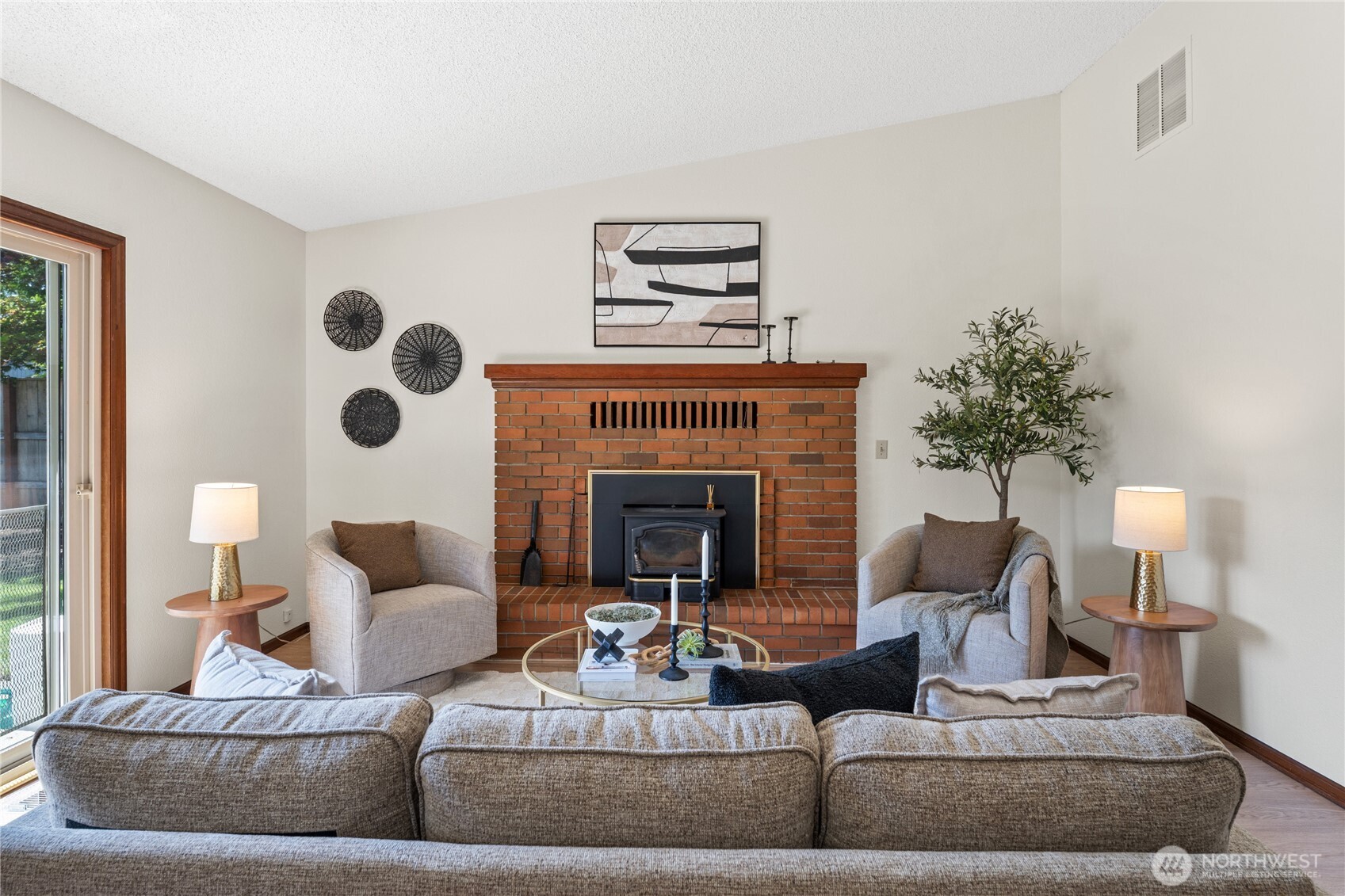 Family room view with wood burning fireplace.