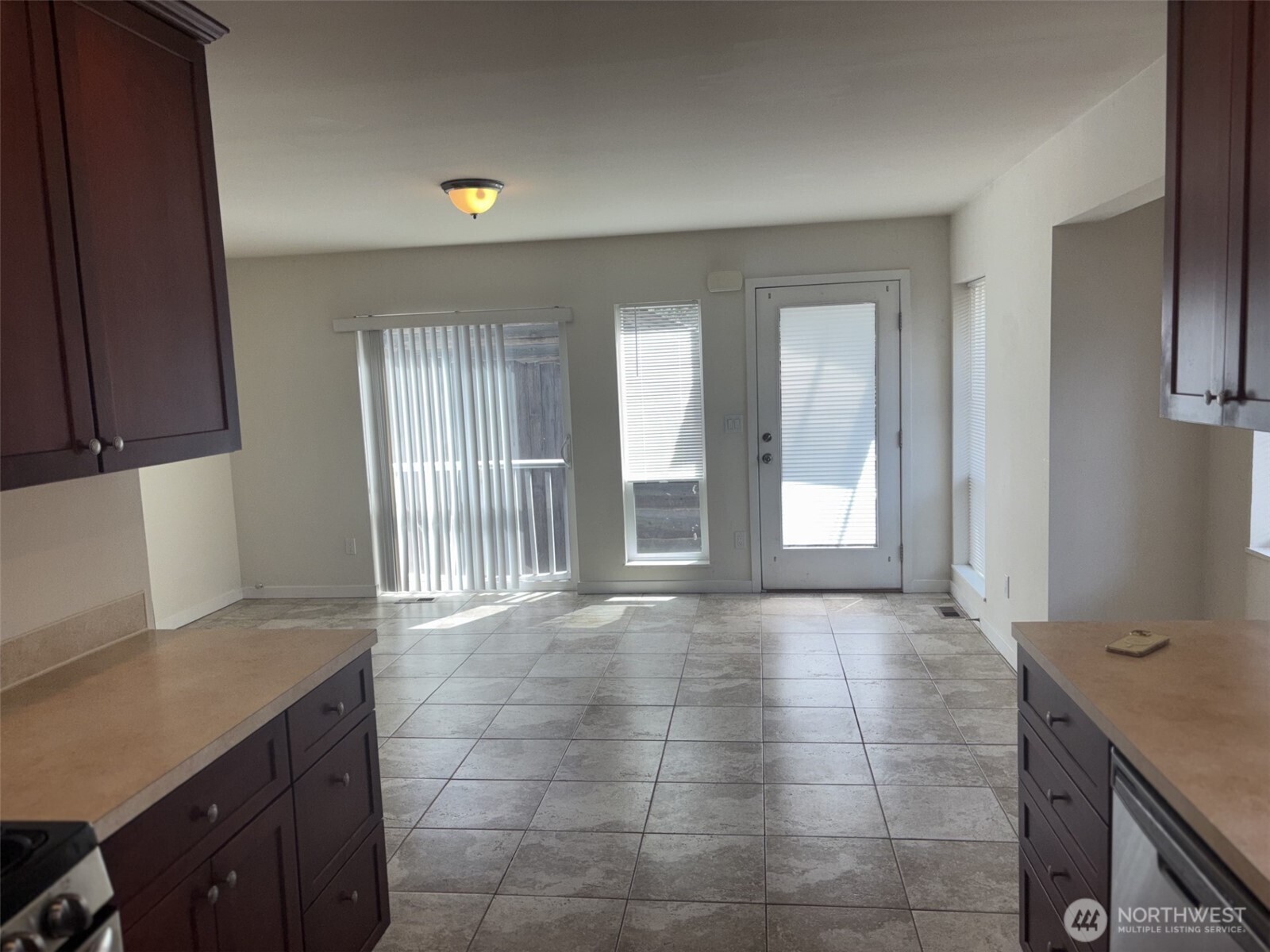 INSIDE we are looking toward entrance to unit.  Again, you find a very spacious open plan with easy maintenance tile floor in the living and kitchen area
