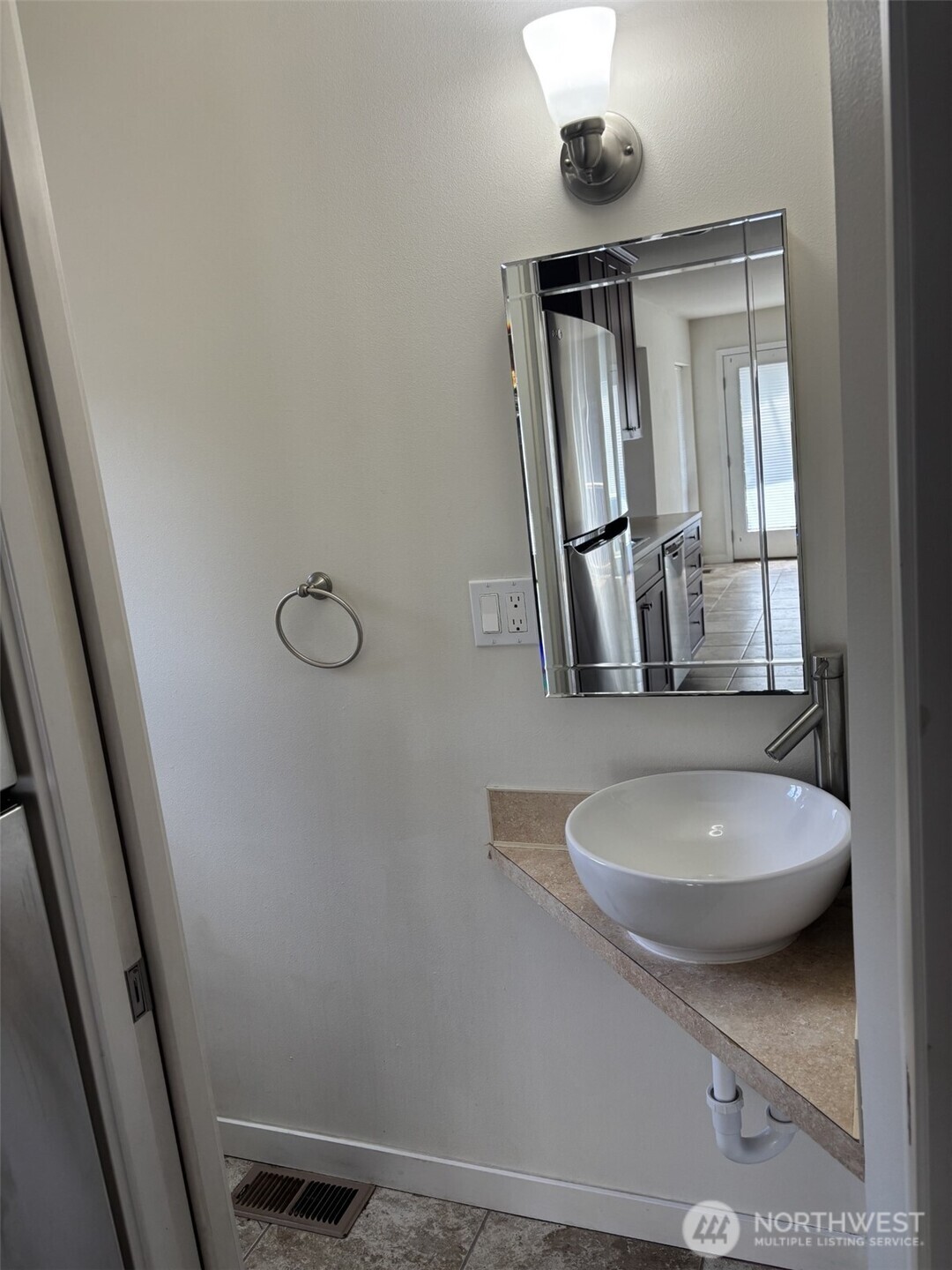 Medicine cabinet with beveled mirror design in powder room.