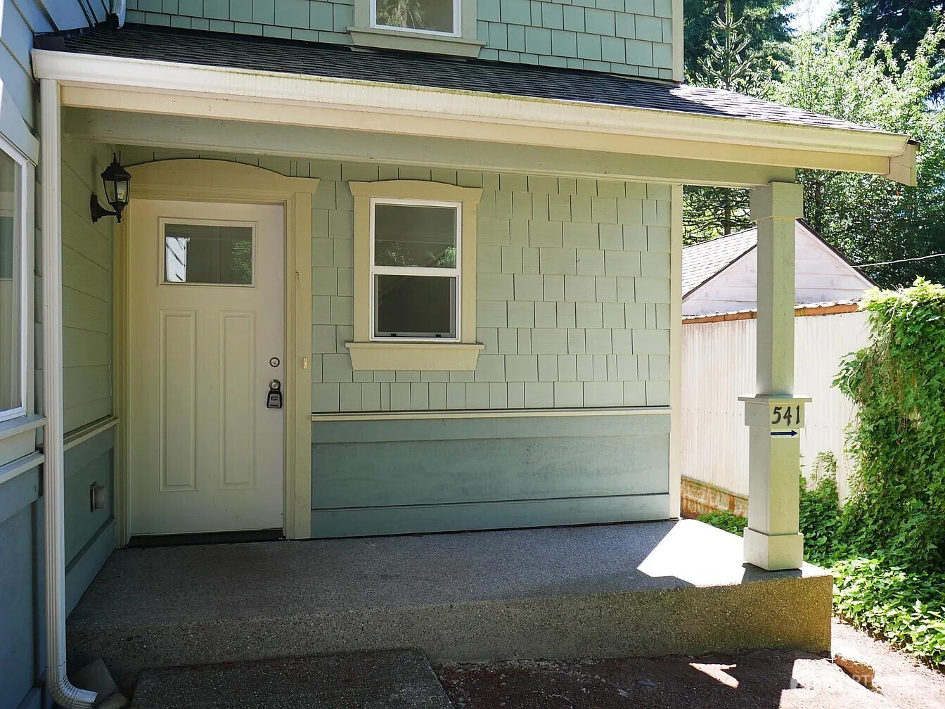 The 2013 building has an attached 2 car garage that has two separate bays, one for upper 3 BR unit and the other for lower 2 BR unit. This covered porch shown here is for Unit #543 and you can see on the post an arrow pointing around back where you will find entry to Unit #541.