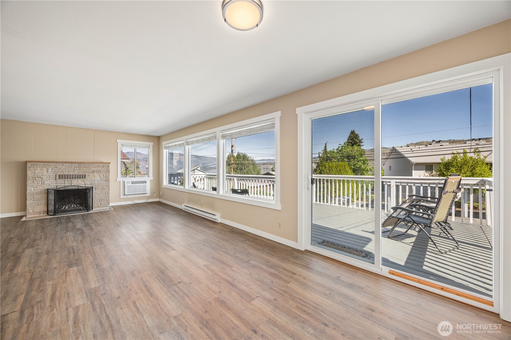 Entryway and living, dining room with oversized windows and glass sliding door leading to the lake view deck.