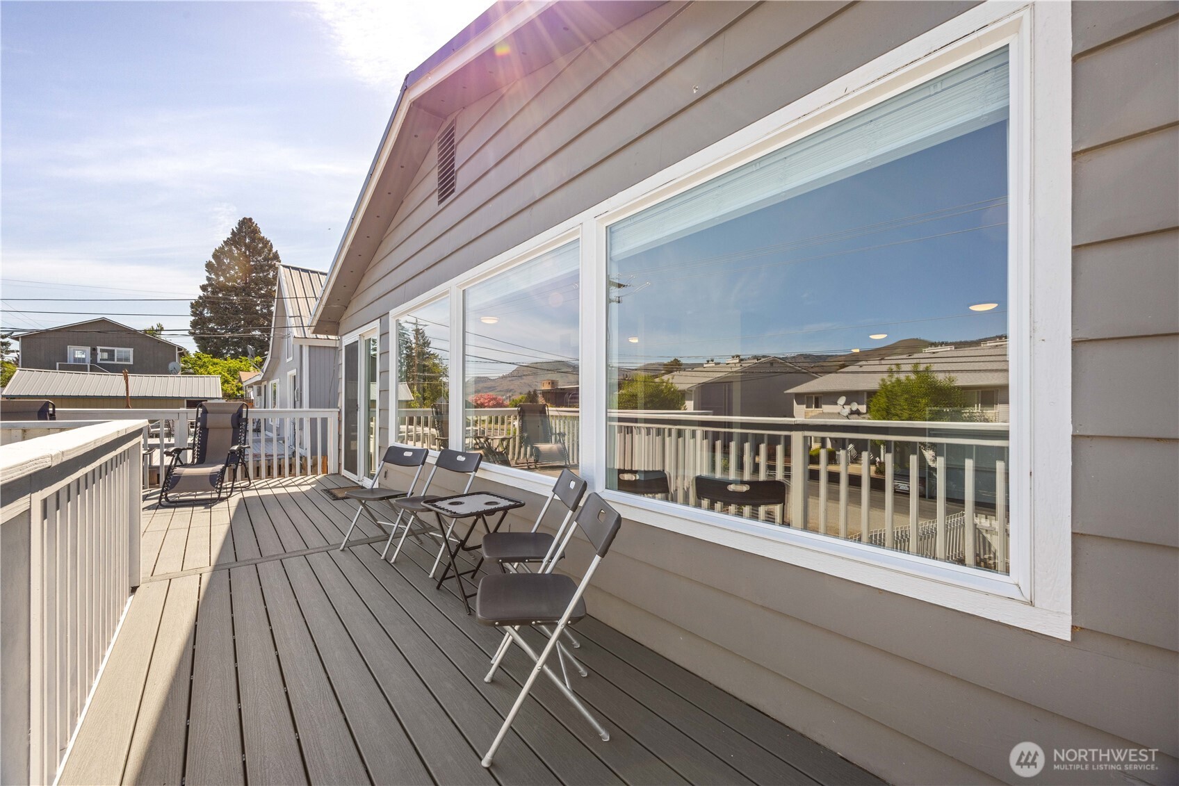 Main level living and dining room with fireplace and glass sliding doors leading to the lake view deck.