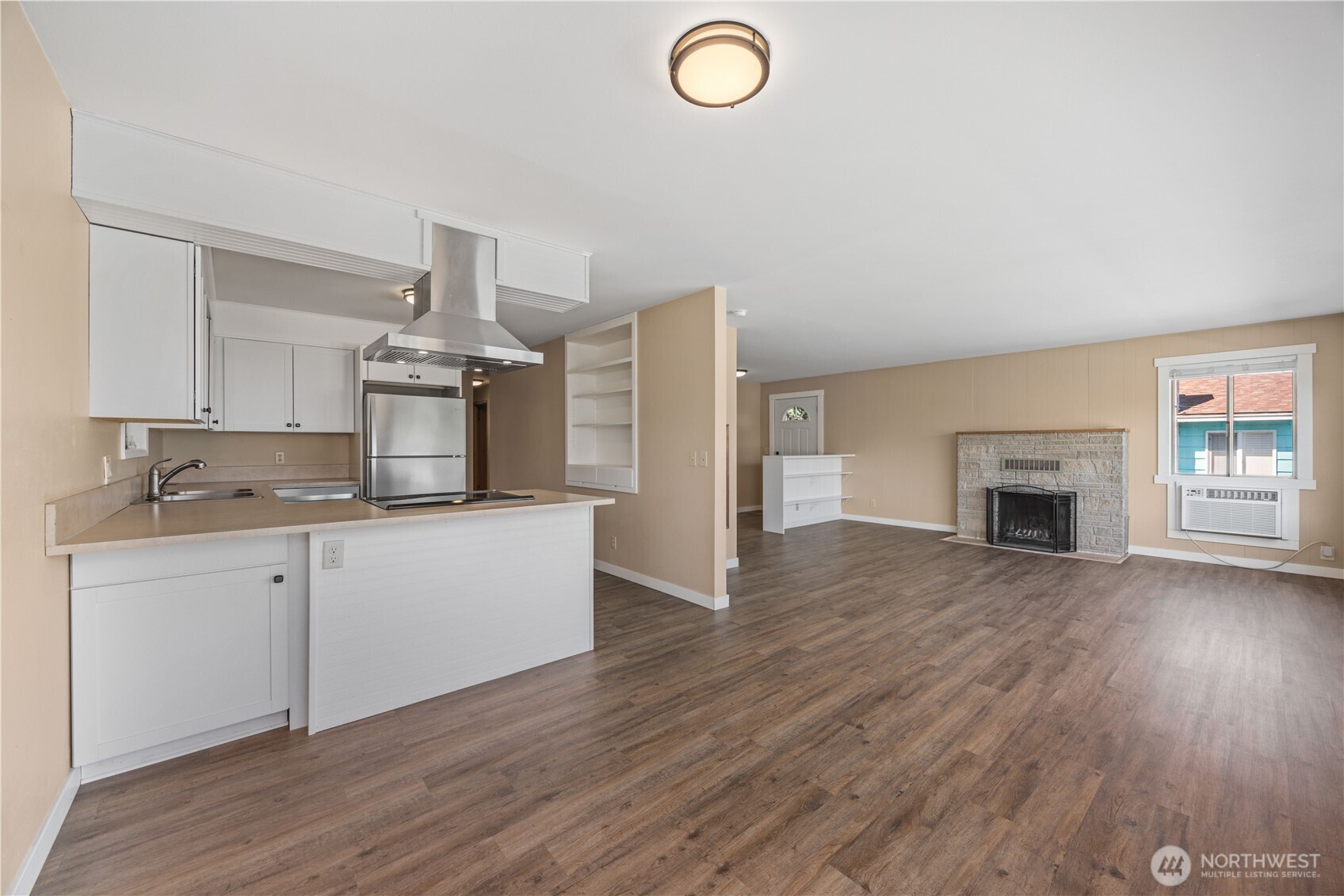 View of 3 of main level kitchen with stainless steel appliances and built in storage.