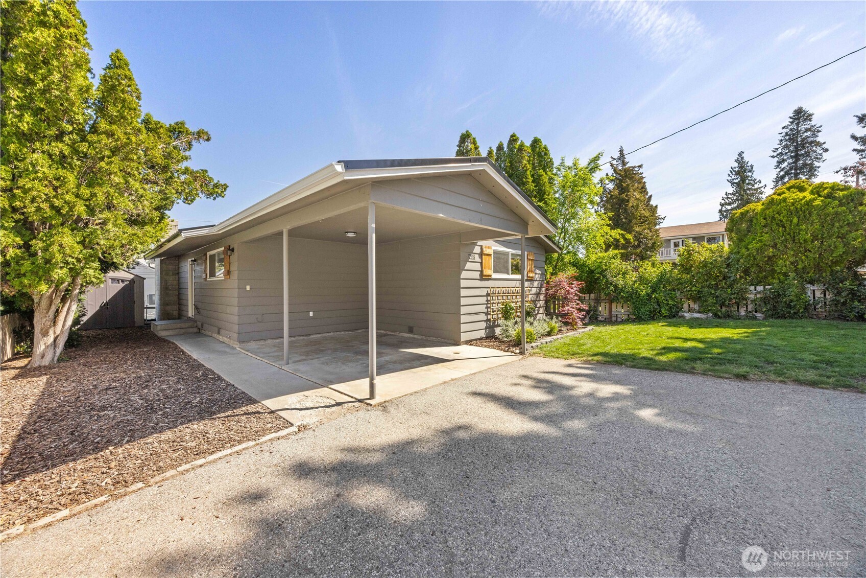 Exterior view of home with driveway, landscaping and fenced back yard.