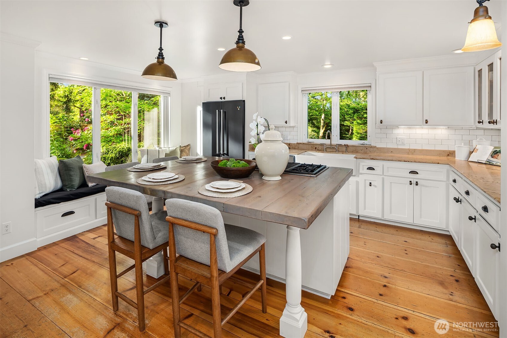 Gorgeous kitchen island made from reclaimed wood make this a very special gathering place with Built-in bench seat with views into the gardens
