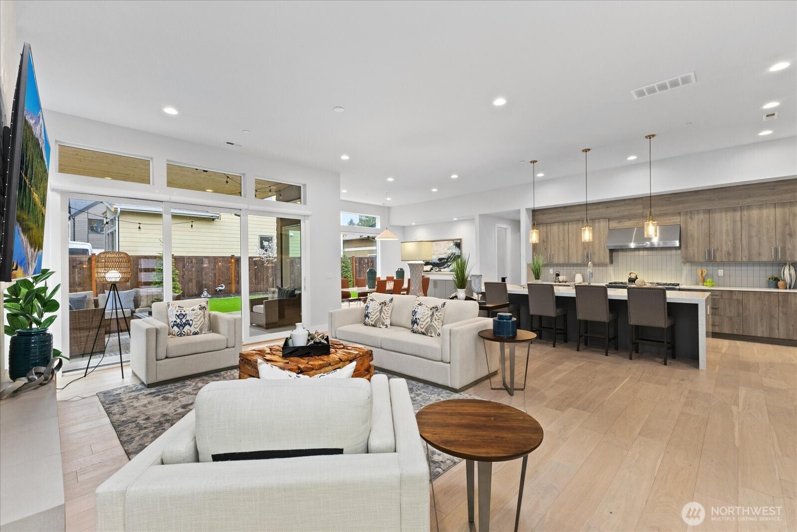 The open-concept living space connects the great room, chef’s kitchen, dining area, and covered patio, creating seamless indoor-outdoor living for everyday comfort and entertaining in this Kirkland North Rose Hill luxury home.