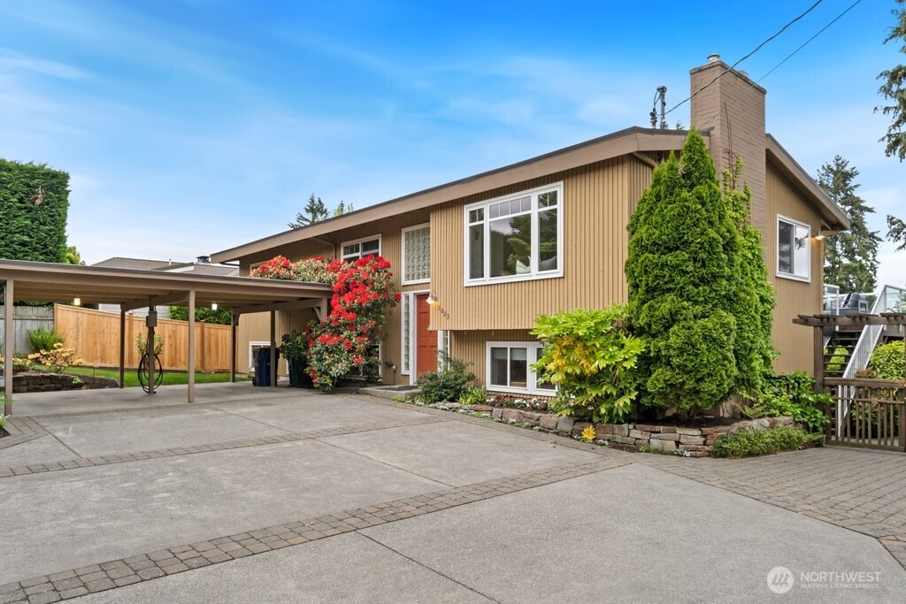 Large two car carport with EV charger and additional parking features a new black top driveway plus cement and brick pavers.