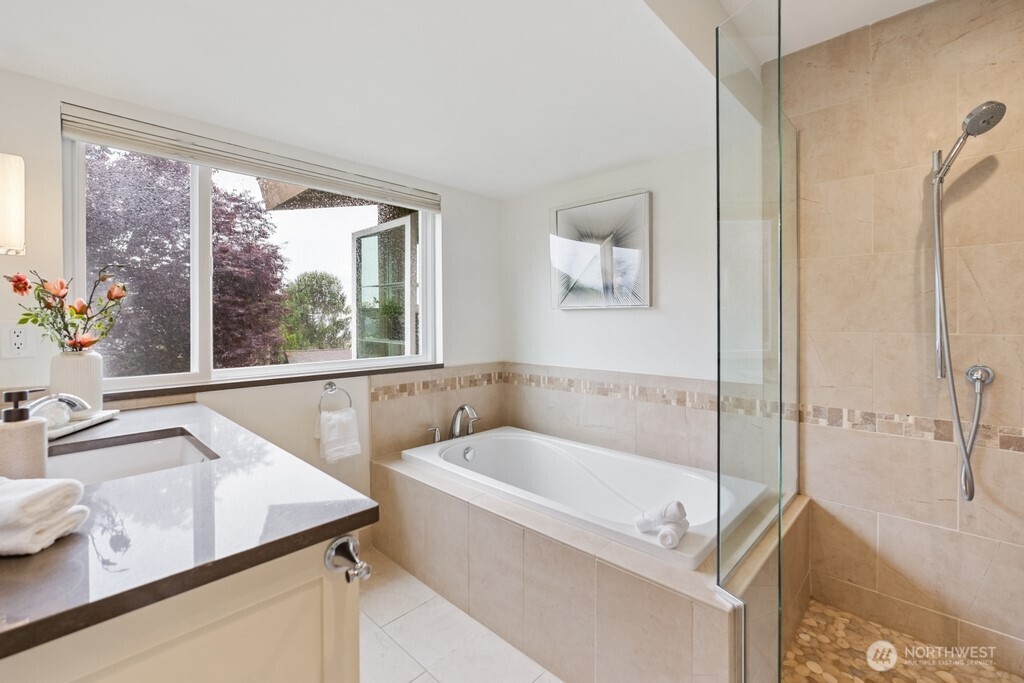 Primary en-suit spa-inspired bath featuring heated floors, walk-in shower and soaking tub