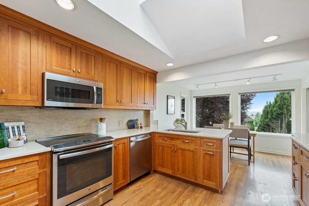 Beautiful light-filled kitchen featuring quartz countertops, cherry wood cabinets and stainless appliances.