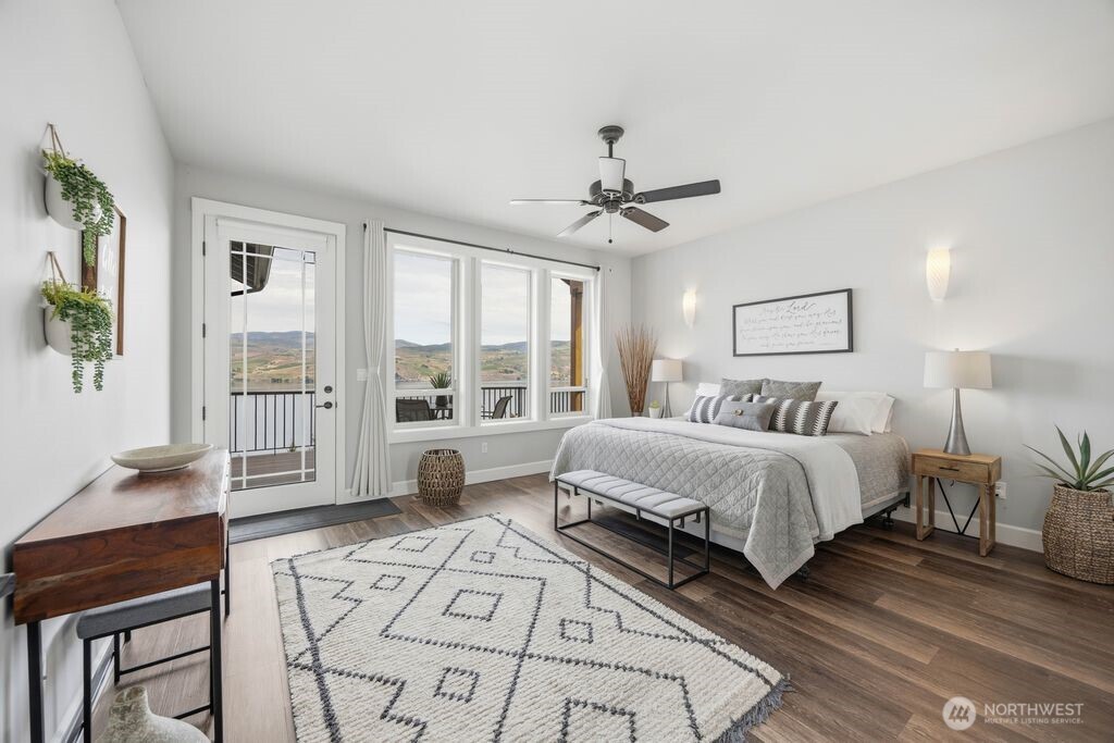 Spacious primary suite with private deck access and sweeping Lake Chelan views creates a peaceful retreat away from the main entertaining spaces. Tucked back privately adjacent to the covered deck, this outdoor sitting area offers a quiet place to enjoy morning coffee or unwind at sunset.