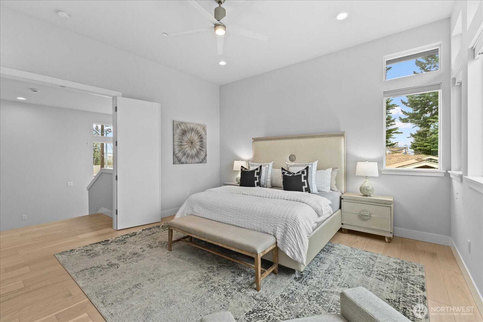 The spacious primary suite offers vaulted ceilings, expansive windows, abundant natural light, and quiet luxury, creating a true private retreat in this Kirkland North Rose Hill home.