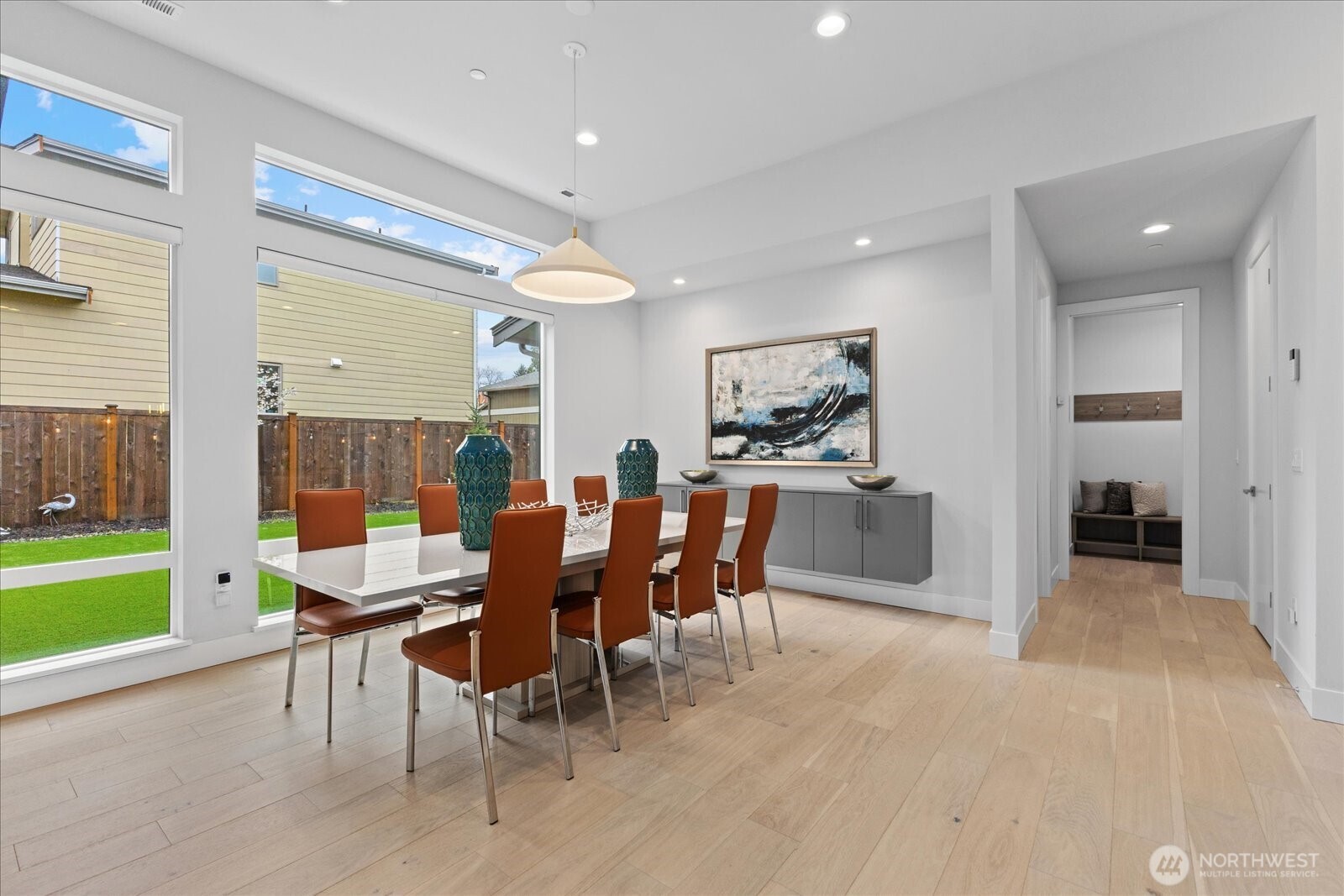 The light-filled dining area features serene outdoor views and seamless flow to the chef’s kitchen and great room, creating an inviting space for everyday meals and entertaining in this Kirkland North Rose Hill luxury home.