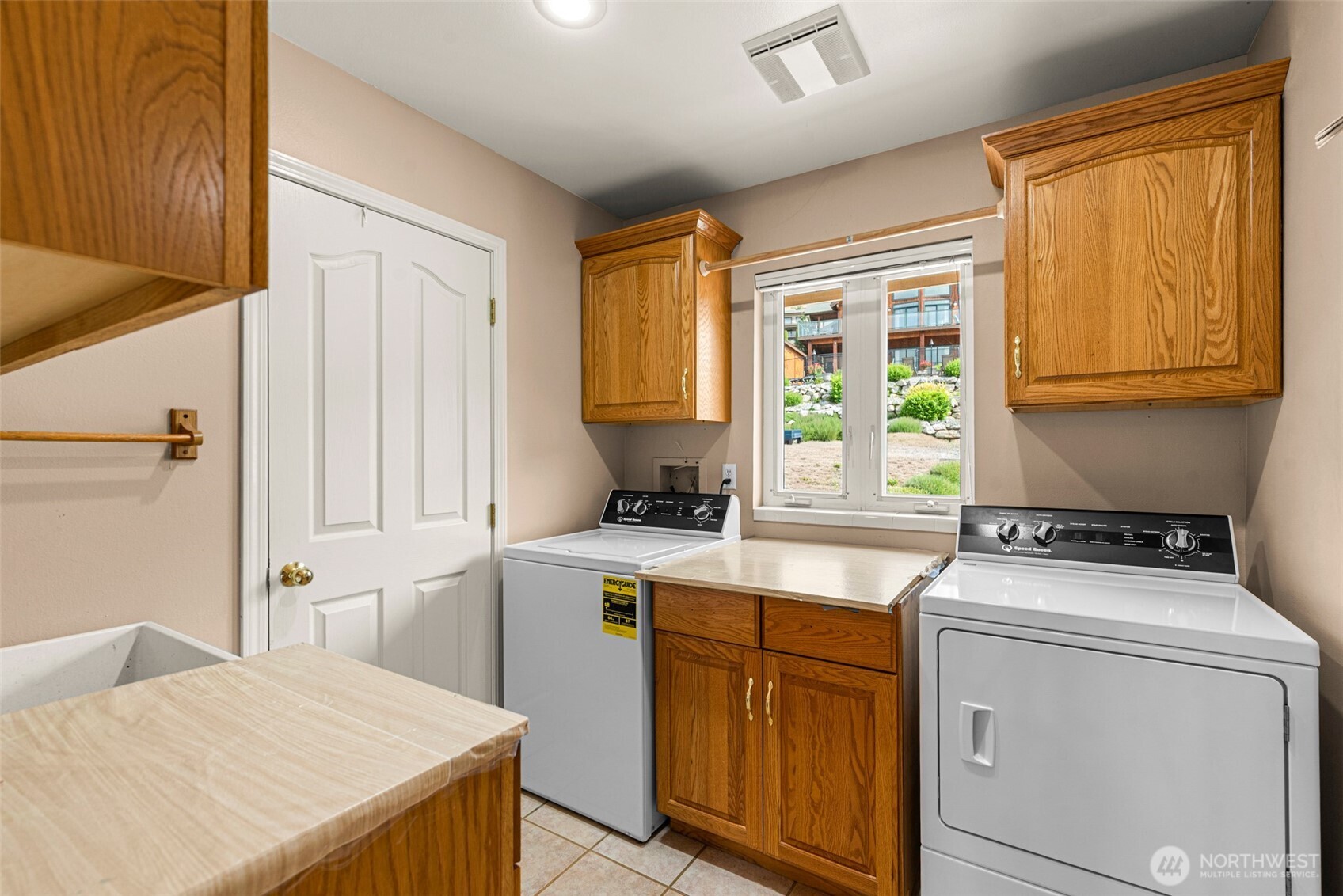 This laundry room has lots of storage and a laundry sink. The washer and dryer are included in the sale.