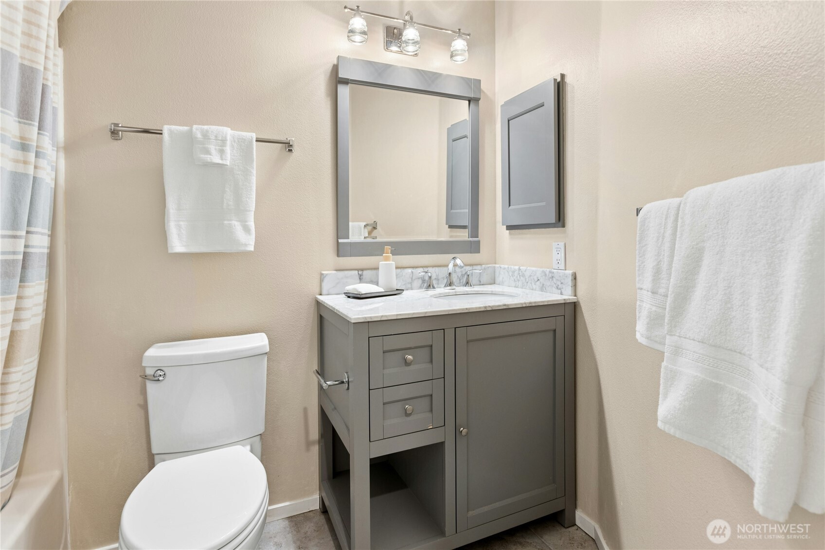 Lower level laundry room with tile floors, Speed Queen washer and dryer, plenty of cabinets and hanging space.