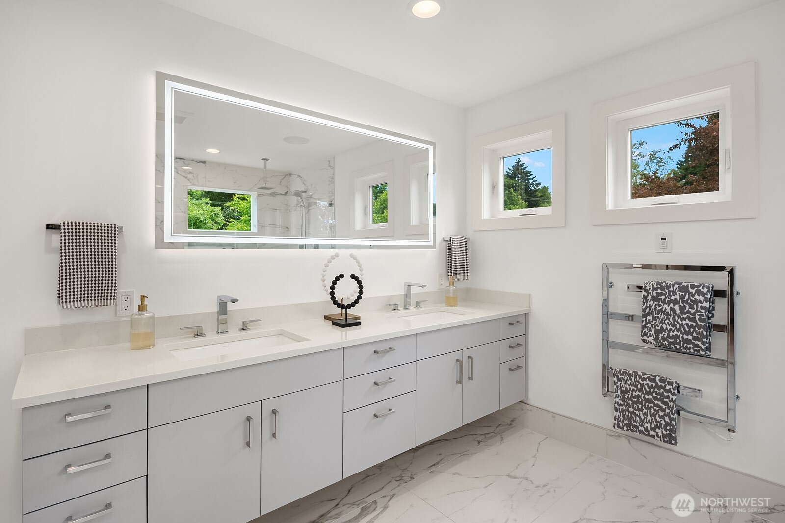 Upper-level primary bathroom - dual sinks, heated floors, lighted mirror, and towel warmer