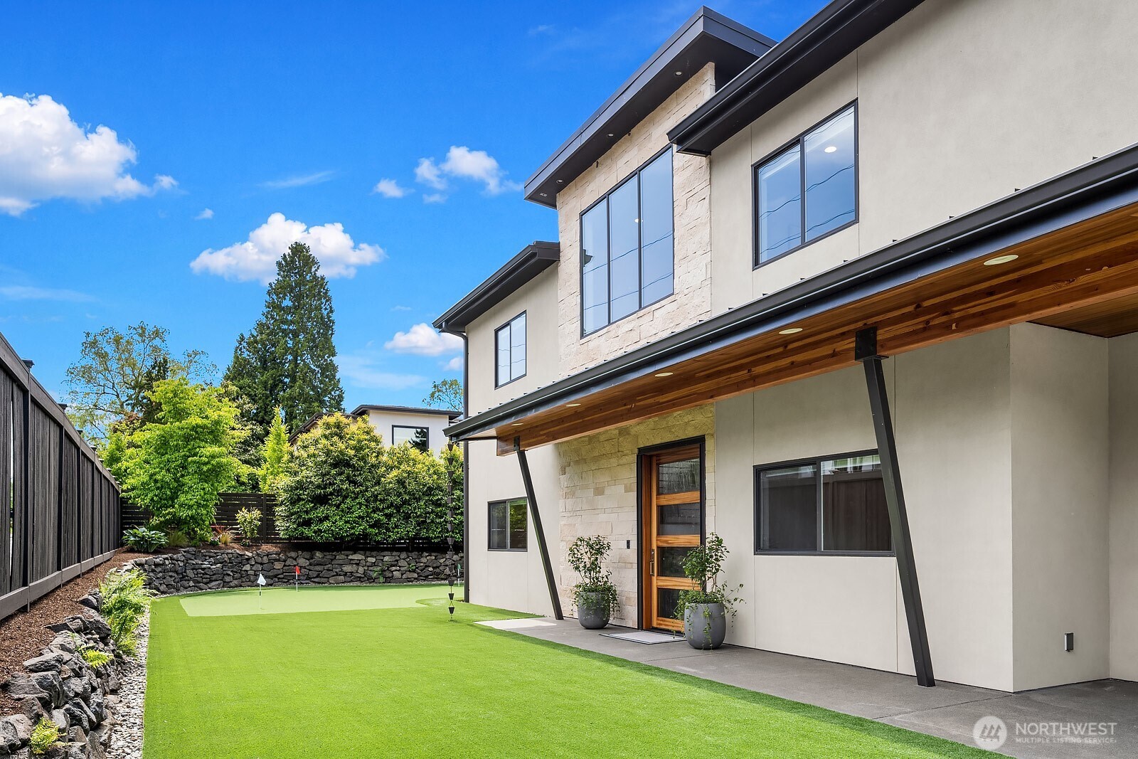 High-quality astroturf yard, beautiful flower beds, sprinkler system, mature trees, and 750 sq ft putting green