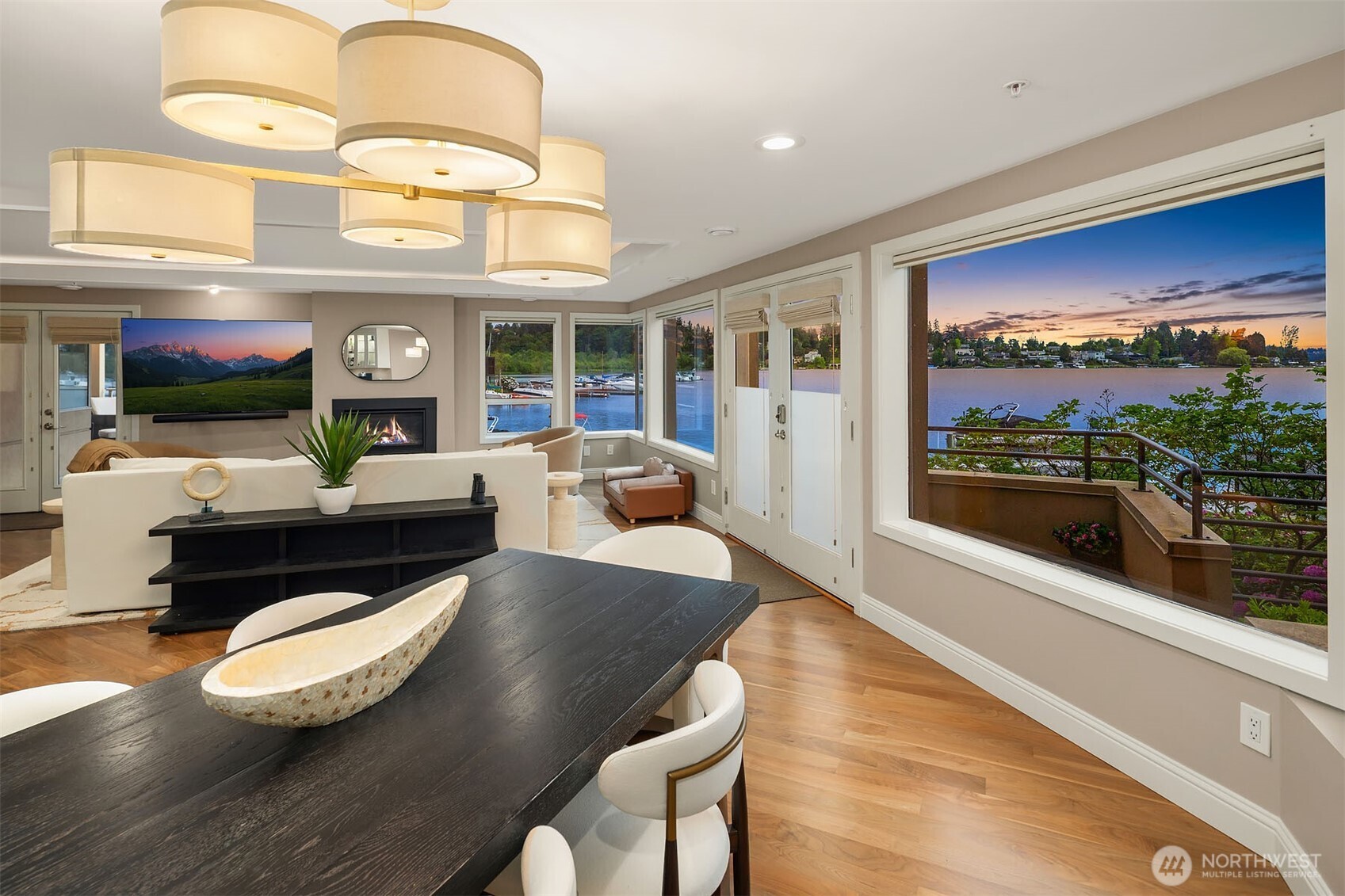 Sunset over Lake Washington becomes the evening's centerpiece — visible from the dining table, from the living room beyond, from every corner of this extraordinary space. With the deck just steps away and the fireplace glowing within, the line between inside and outside simply disappears.