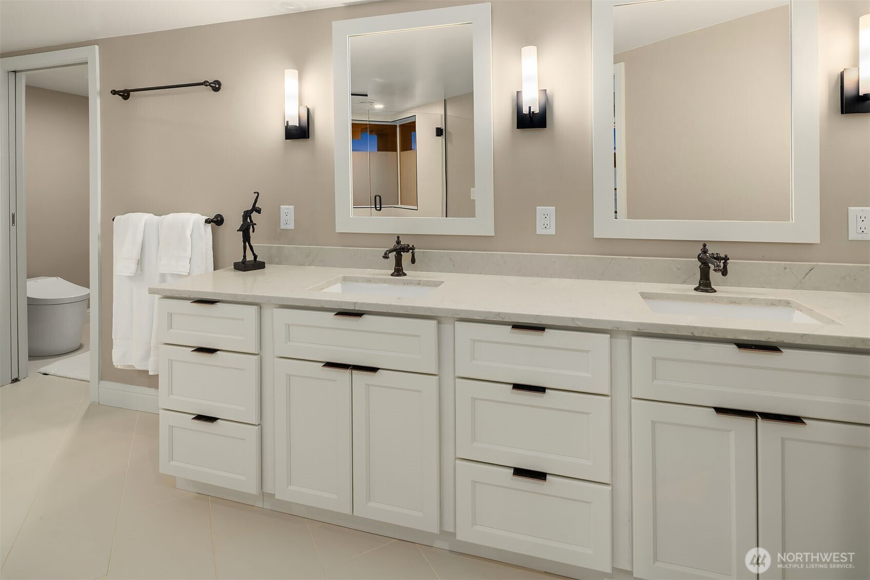 Every detail of the primary bath speaks to a standard of living that is quietly exceptional — a sprawling dual vanity with marble countertop, abundant drawer storage, oil-rubbed bronze faucets, and a private water closet with Toto toilet. The kind of bathroom that makes getting ready feel less like a routine and more like a ritual.