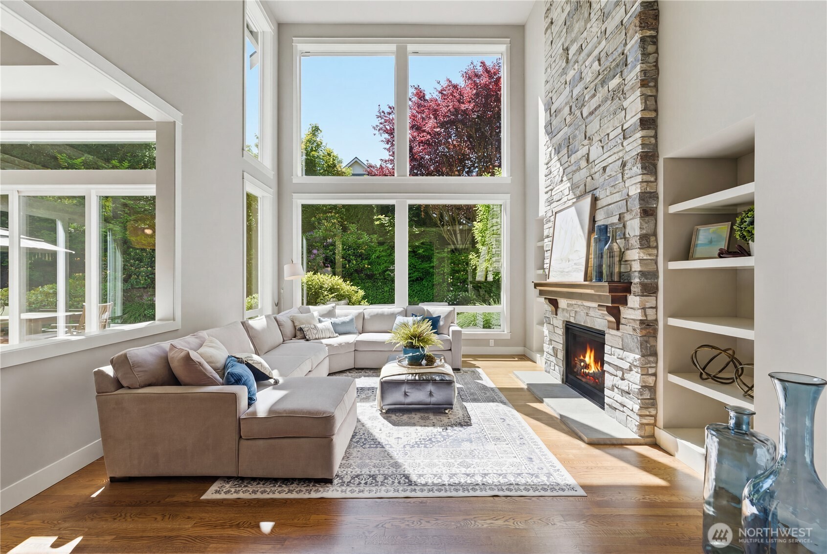 Step inside to soaring windows and a lush, uninterrupted green backdrop. Double-height ceilings bring volume and quiet drama to the family room