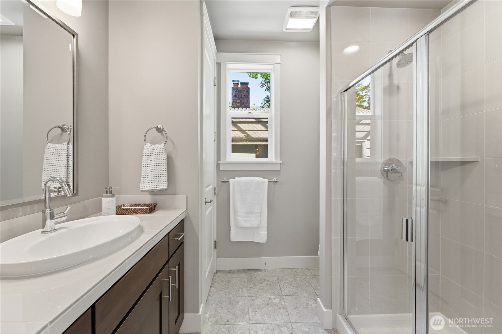 Back inside, the main-floor 3/4 bath offers a spacious shower, beautifully finished cabinetry, and a full-height closet for extra storage.  Just outside the window, the custom-built shed offers sheltered winter storage for garden furniture and more