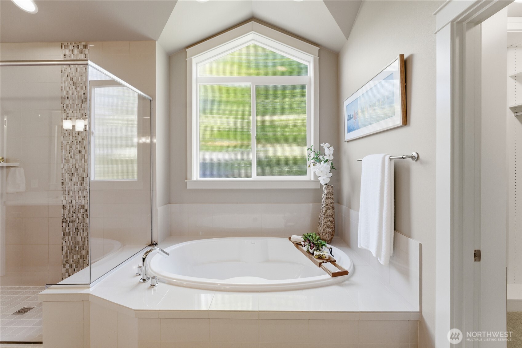 A beautiful tub framed by an oversized window that pours natural light into the room