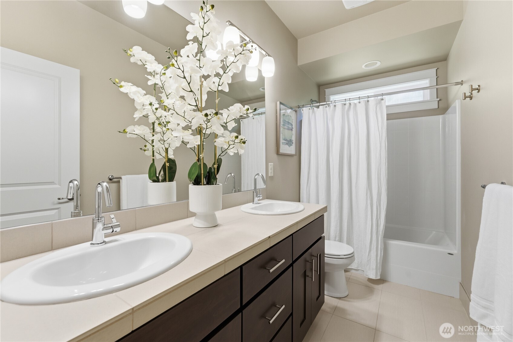 This hallway 3/4 bath serves the two additional second floor bedrooms ~ double vanity and includes attractive floor tile plus a working window for fresh air and light
