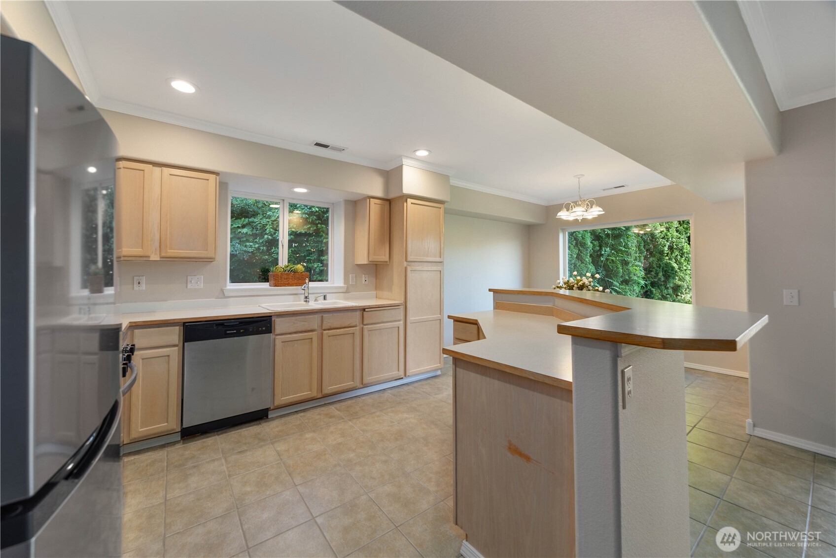 Beautifully updated kitchen featuring new stainless steel appliances, abundant cabinetry, and expansive counter space designed for both everyday living and entertaining. The open-concept layout flows seamlessly into the dining and living areas, while large windows bring in natural light and create a bright, welcoming atmosphere. Clean finishes and modern touches complete this functional and stylish kitchen space.