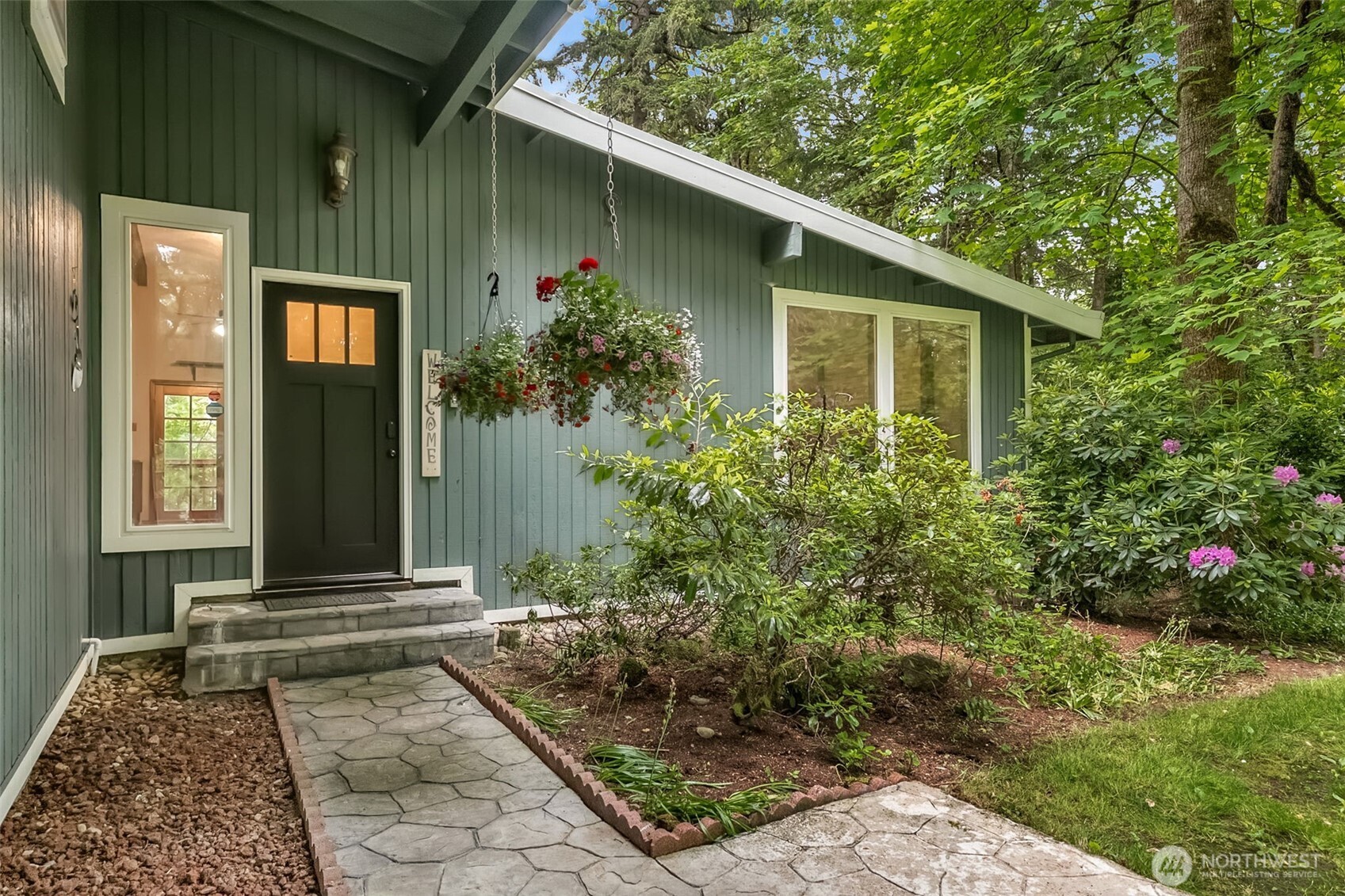 New classic style front door, stamped concrete walkway, and covered front area welcomes guests who can stay dry here all year round while you answer the front door!