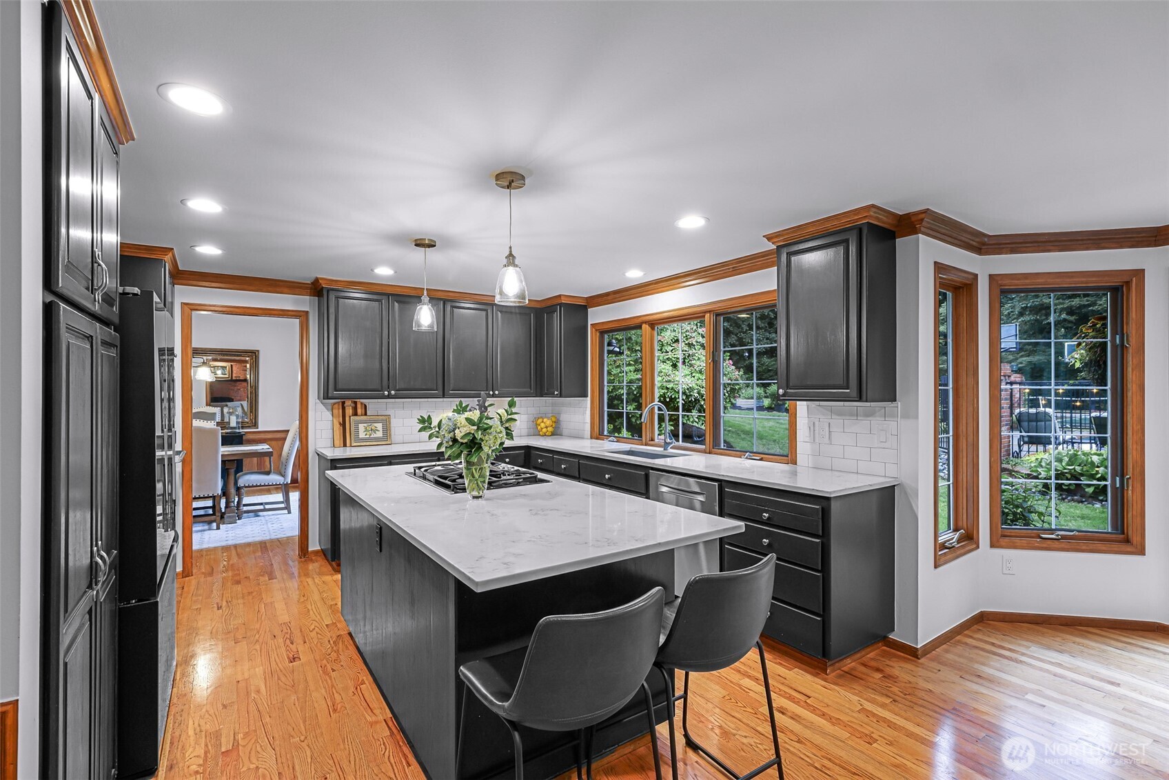 Kitchen off dining room with quartz counters, large island and stainless appliances.