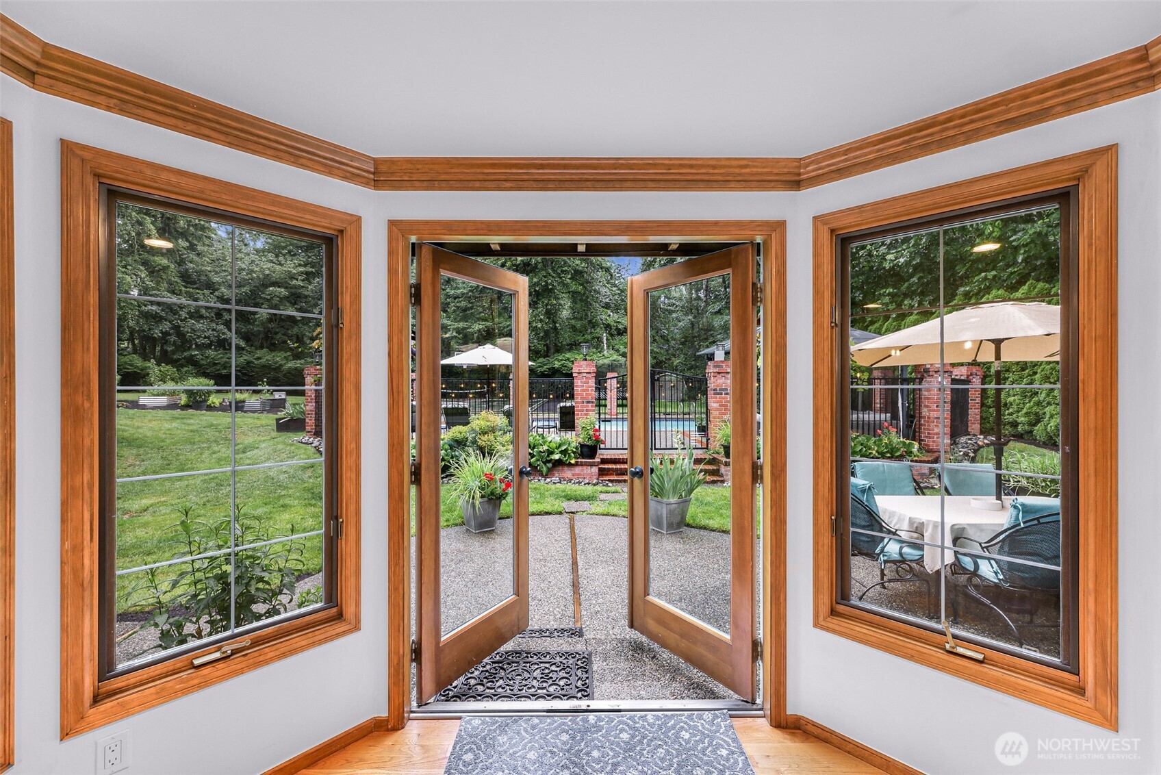 French Doors off kitchen sitting area leading to a patio and the gorgeous pool.