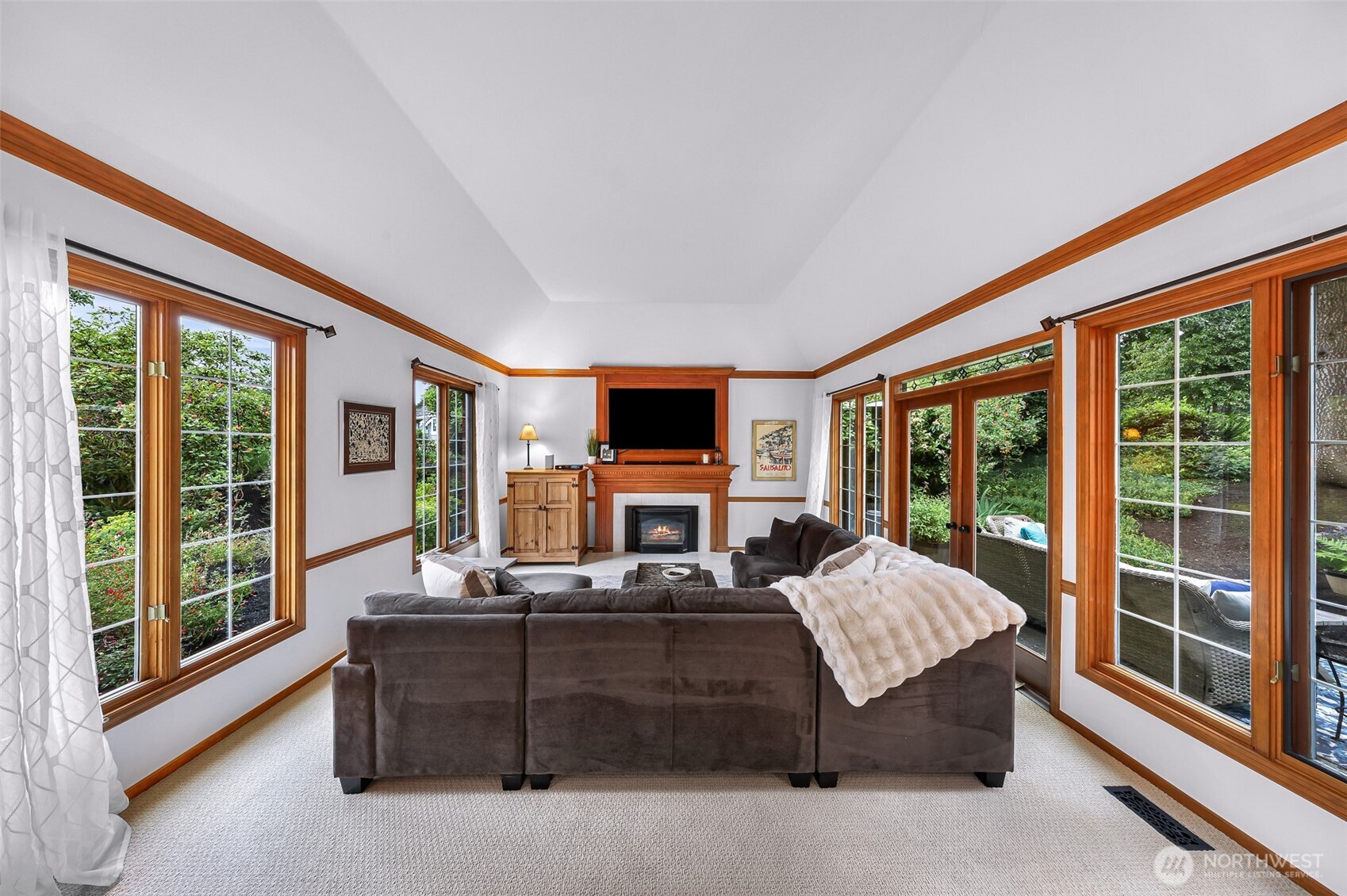 Cozy gas fireplace and French doors opening to a patio.