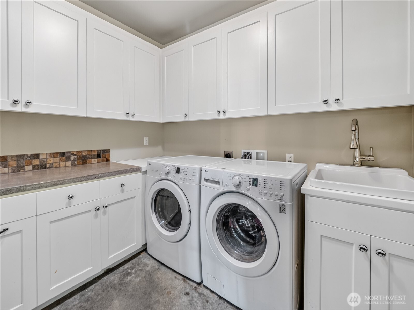 Detached ALU laundry room with abundant cabinet storage.