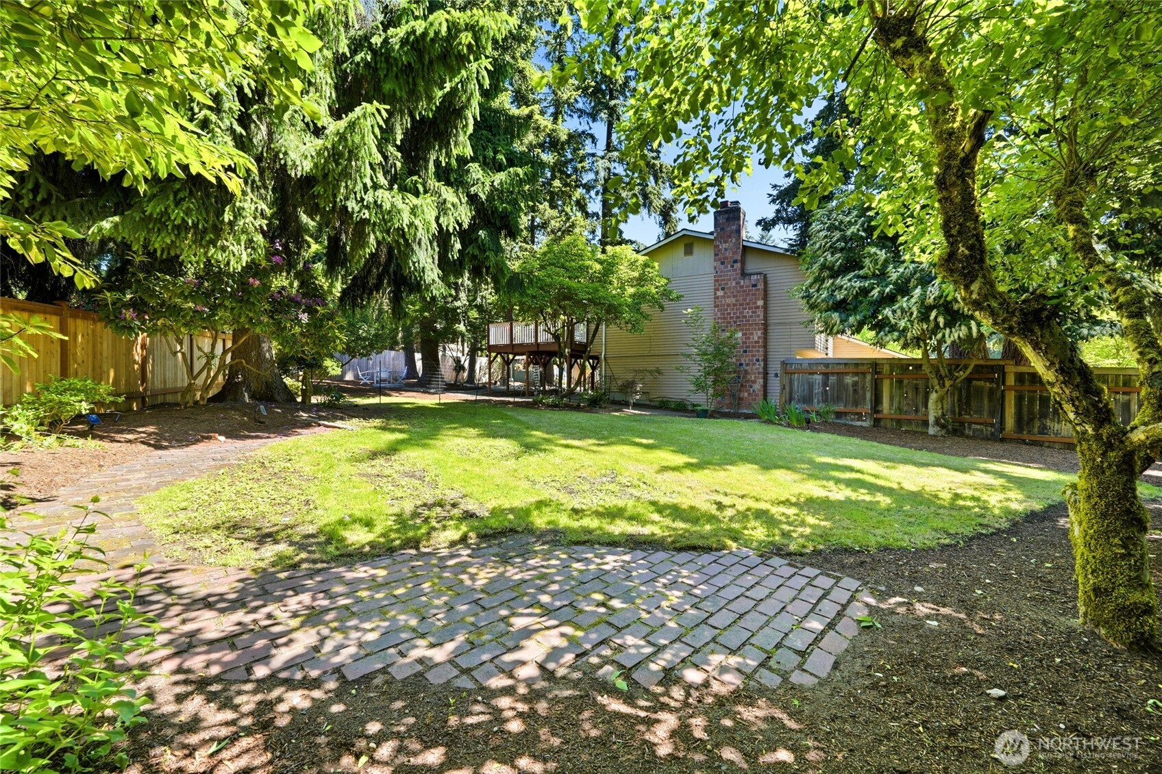 Beautiful mature trees surround the fully fenced yard creating privacy and shade throughout.