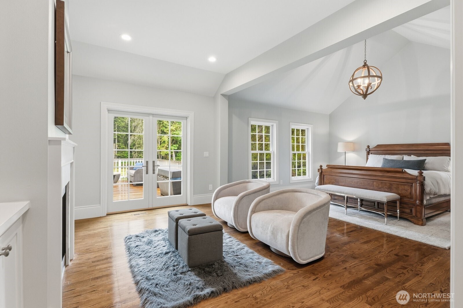 The luxurious main-level primary suite serves as a private sanctuary, complete with its own marble surround fireplace flanked with built-ins.