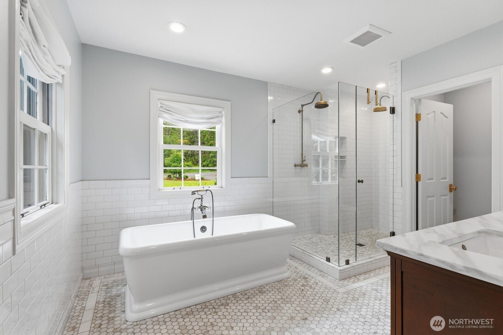 Free standing soaking tub, custom vanity and a large walk-in closet.
