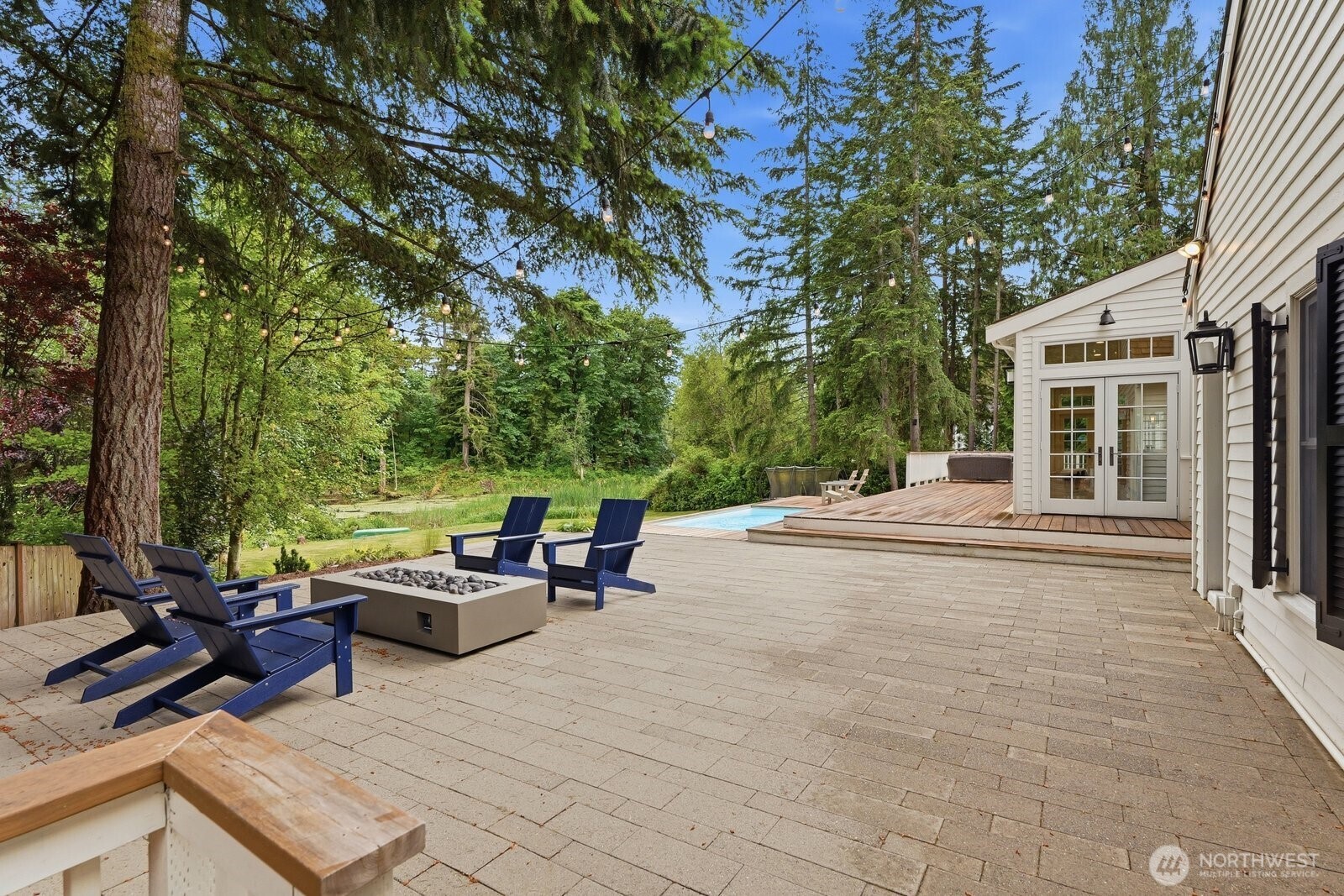 A stone patio with a fire table for year-round entertaining, a charming treehouse and a garden shed.