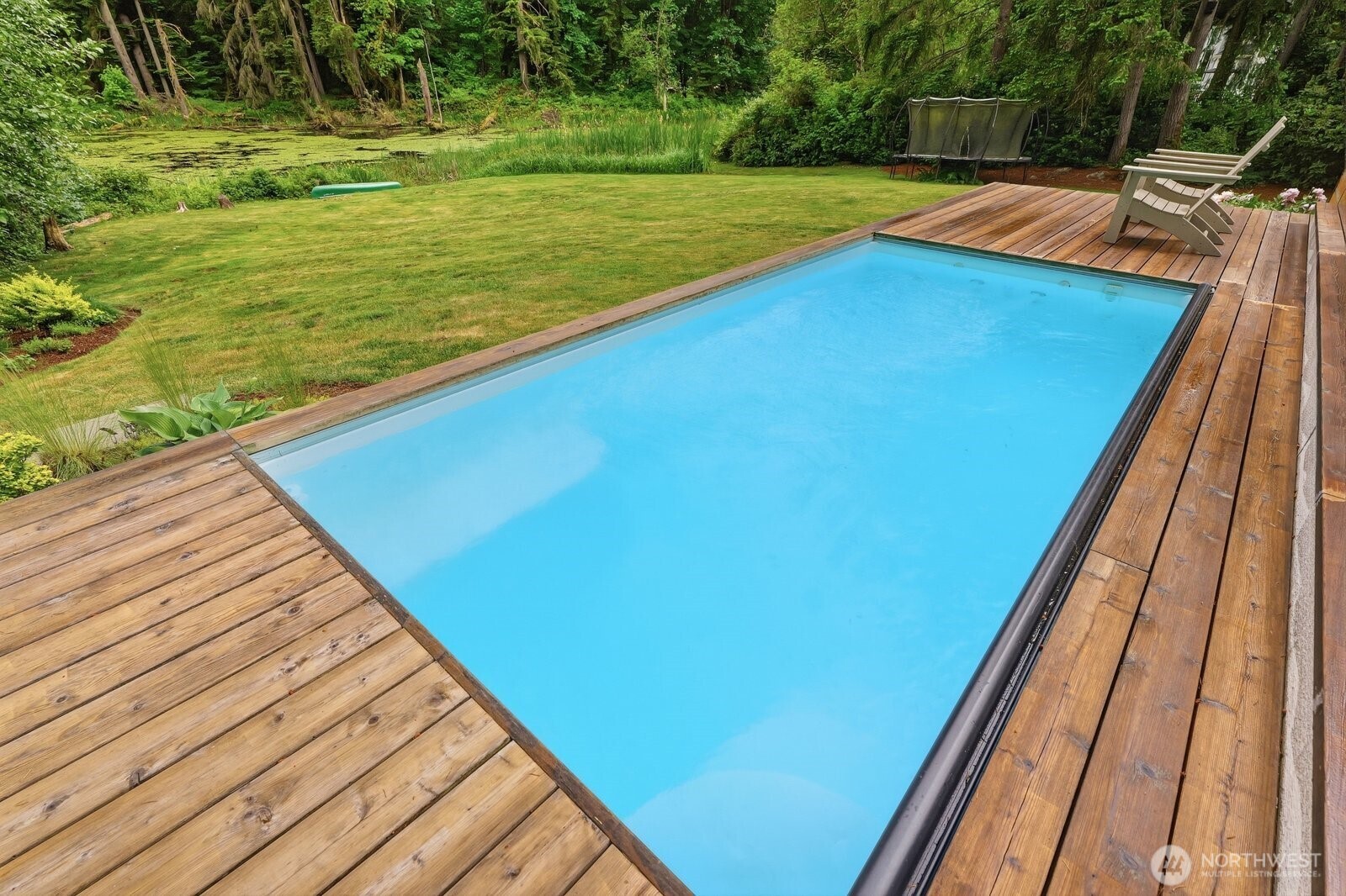 Overlooking the serene yard with your own natural pond and evergreen back drop.