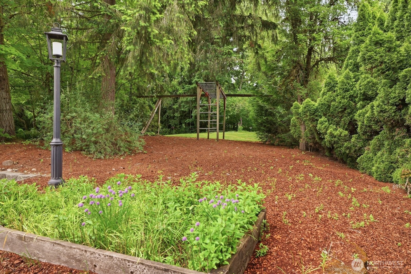 The front side yard with raised garden bed and play structure.