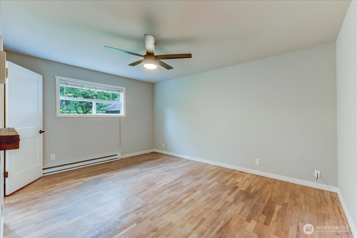 primary bedroom with ceiling fan and electric fireplace