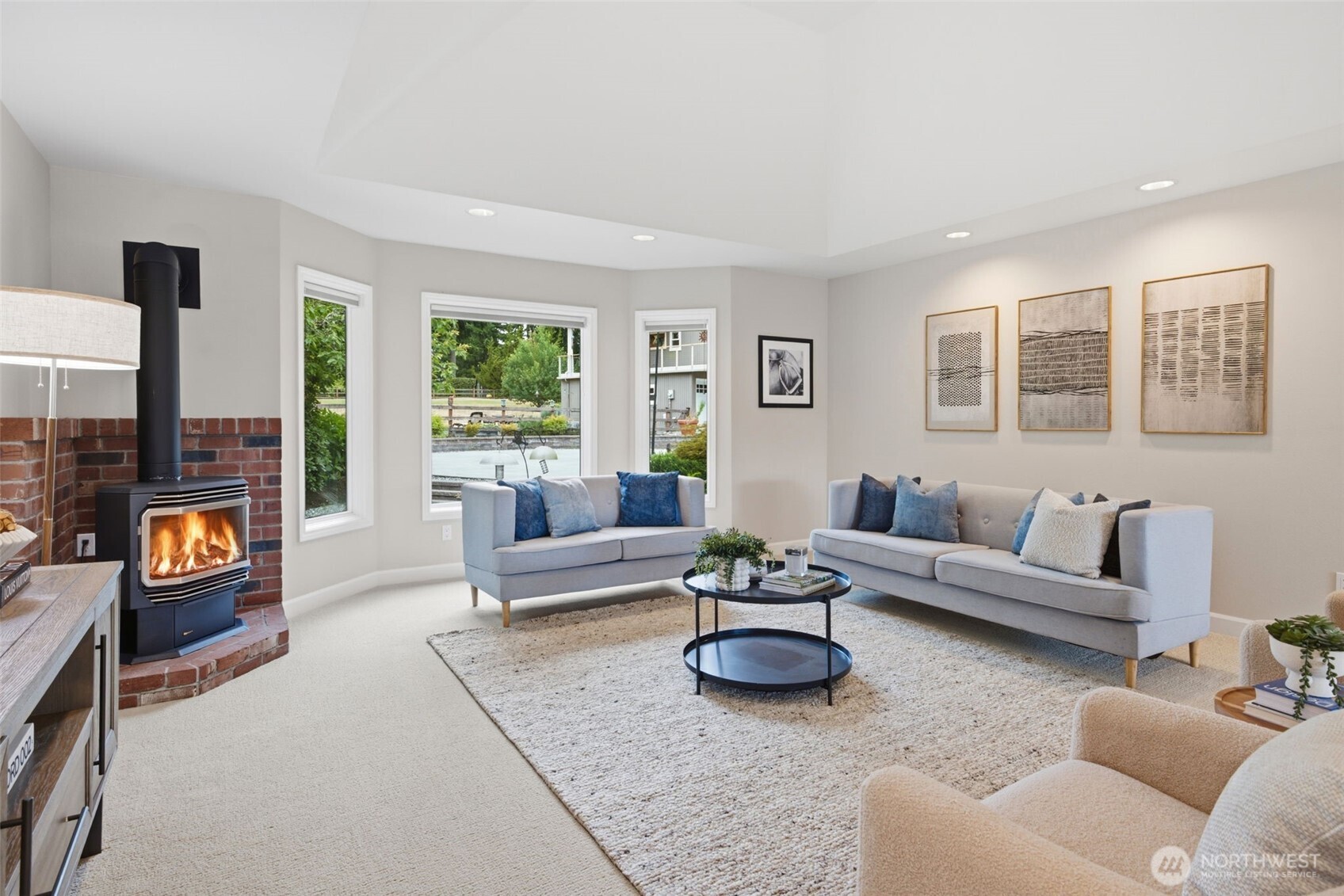 Living room open to kitchen and dining nook, with a cozy gas fireplace