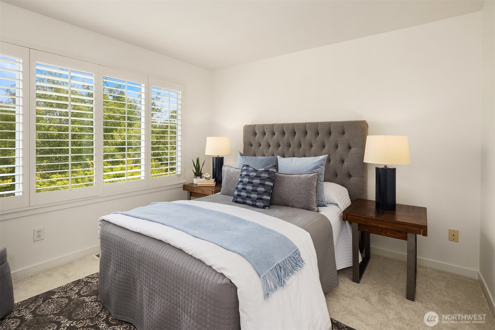 The primary bedroom has plantation shutters and overlooks the green space out back.
