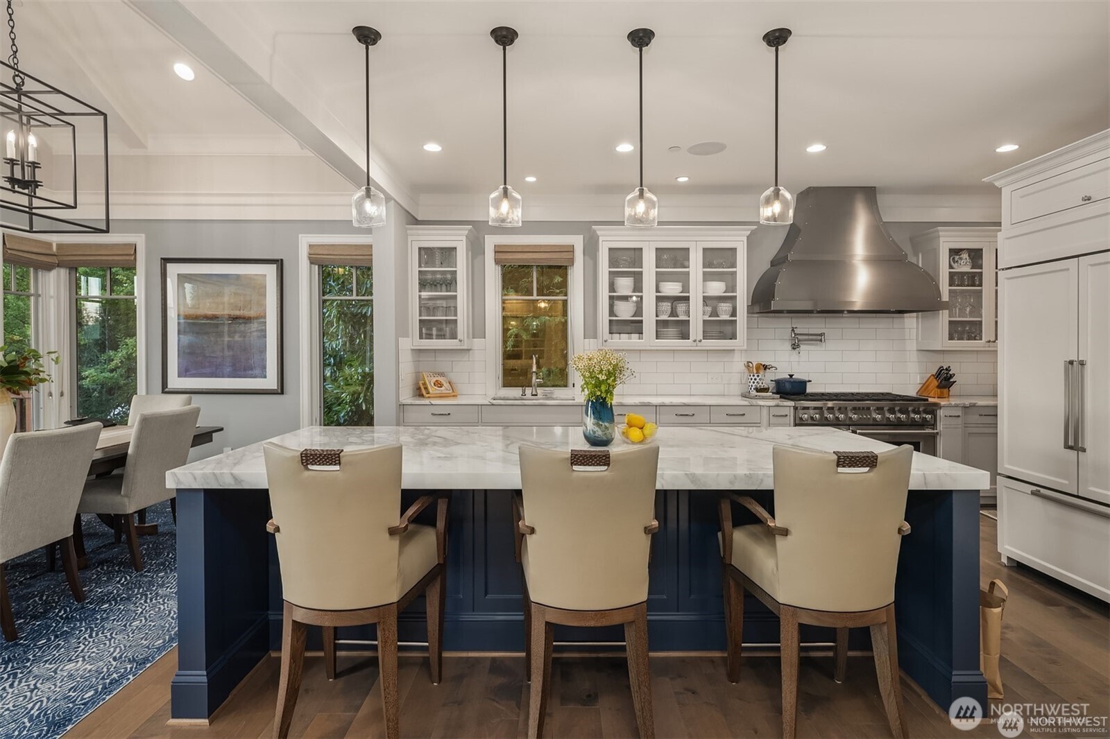 The chef's kitchen is as stunning as it is functional-gleaming with white marble countertops that crown an oversized island. Two subzeros, two sinks and three ovens makes entertaining a breeze!