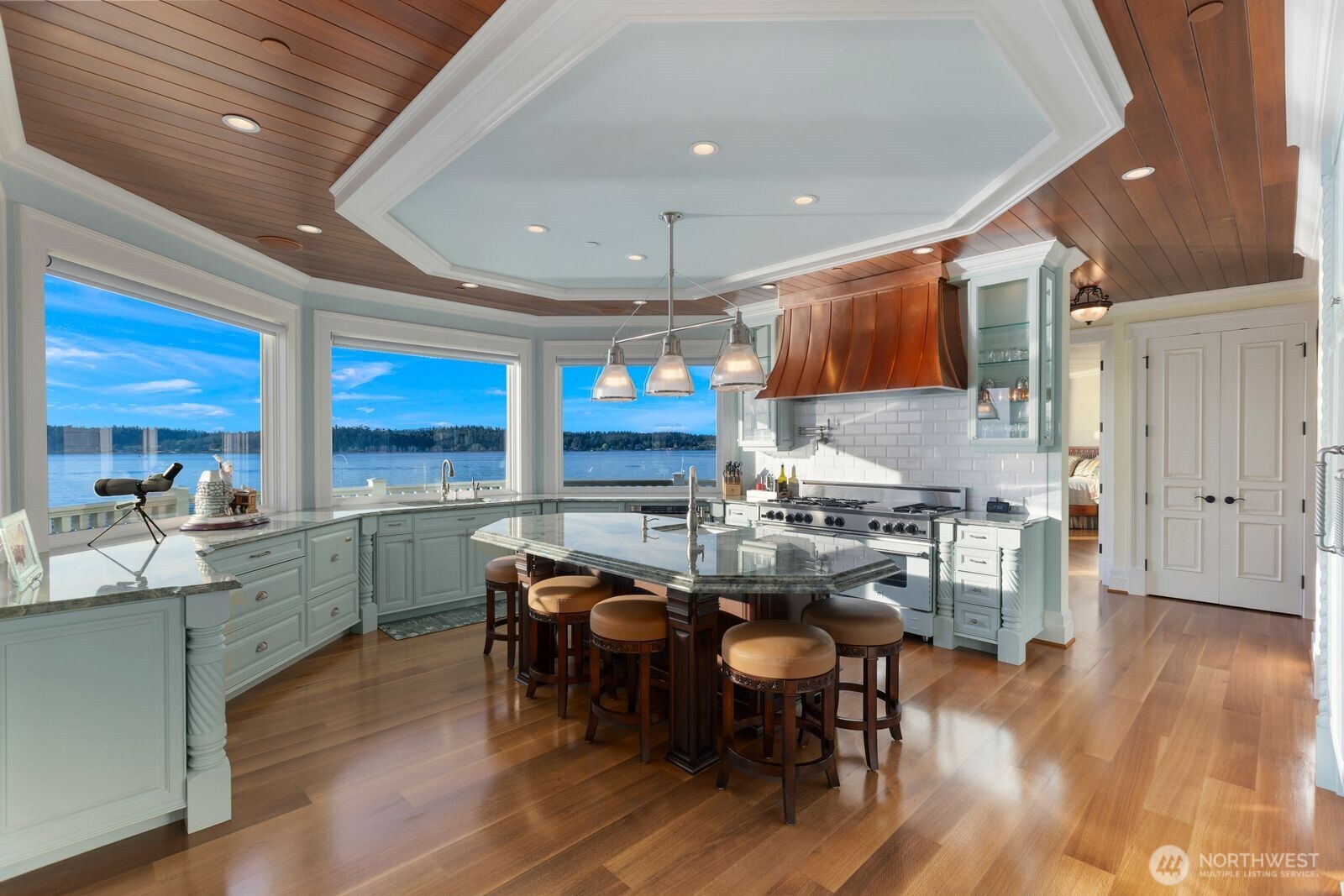 The chef's kitchen features premium appliances, custom cabinetry, generous prep space, and inspiring views in every direction.