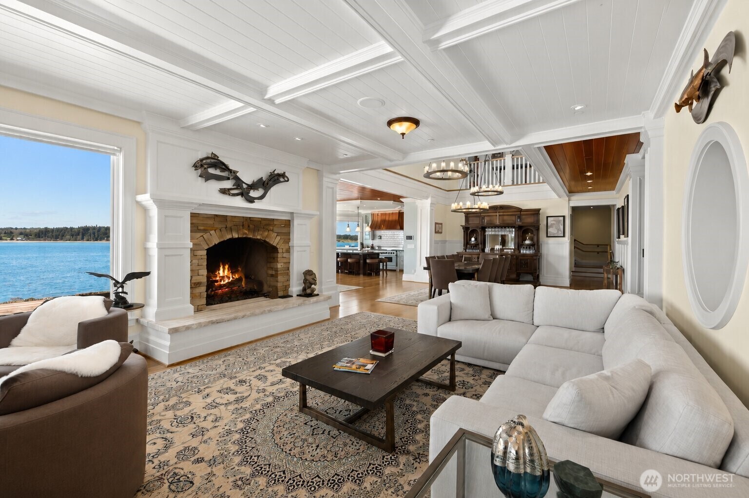 The great room offers an ideal blend of comfort and elegance, centered around a beautiful fireplace and endless water views.