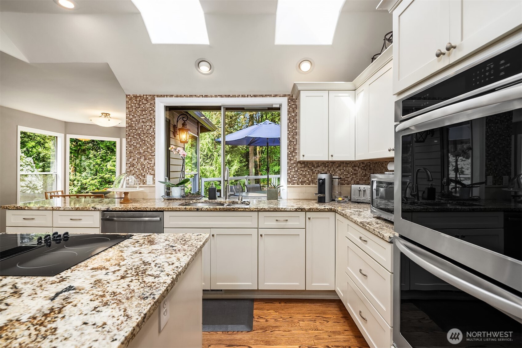 Spacious eat-in kitchen nook leads to upper outdoor deck.