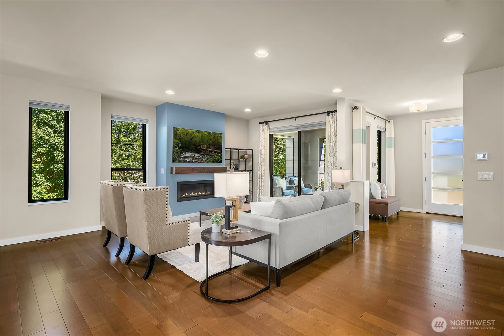 Living room with sliding doors to the patio. The fireplace with accent wall and custom mantel is just one of the upgrades and sophisticated design touches the owner added