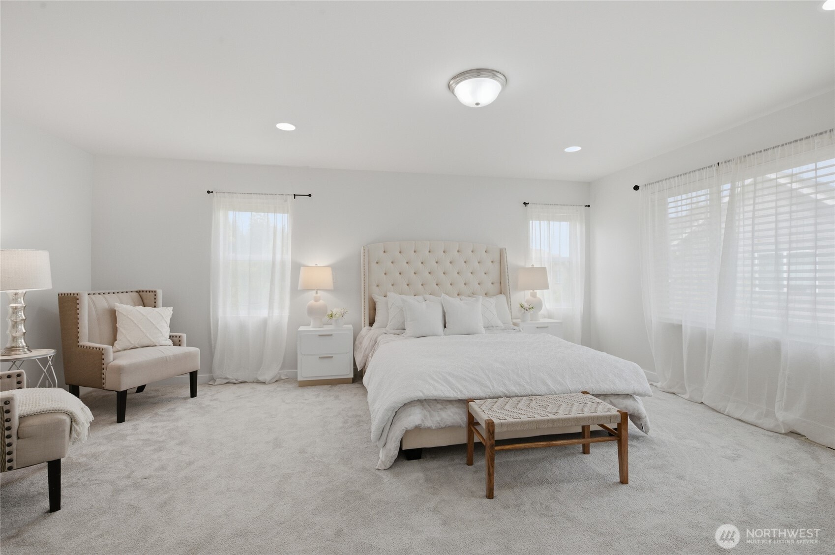 Elegant primary suite has room for a sitting area and is flooded with light!