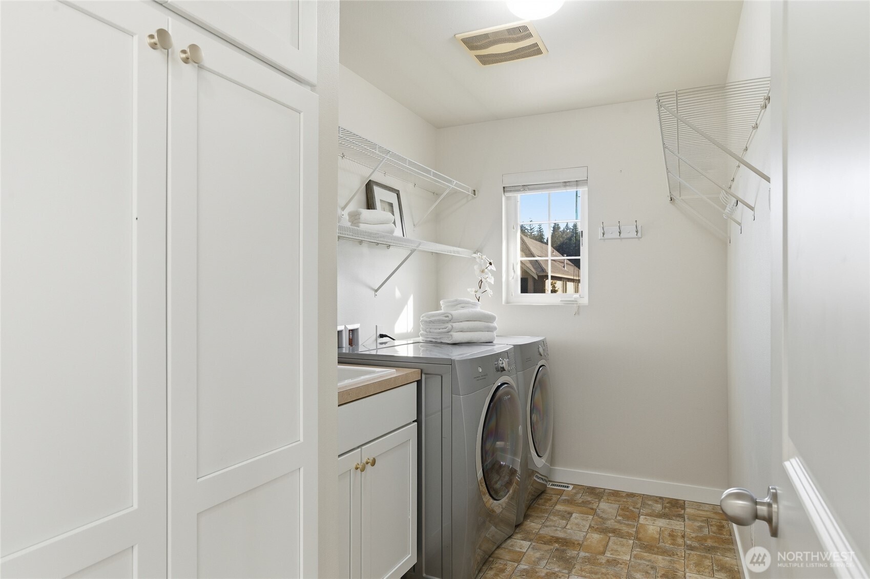 Convenient laundry room with lots of cabinetry and utility sink!