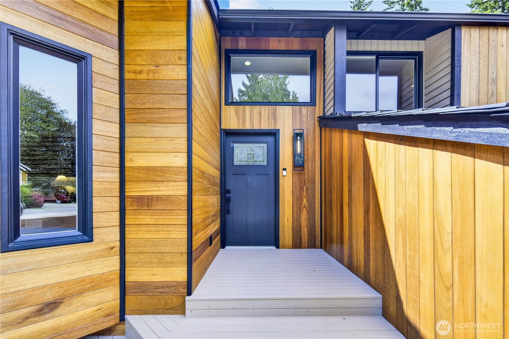 Refreshed front siding and black trim bring out the home’s Pacific Northwest style, while the new front door adds a polished modern touch with its Craftsman-style panels and decorative glass inset. A tall caged lantern sconce with textured glass and an Edison bulb adds a clean contemporary accent. All exterior doors are new, and one matching key opens them all for everyday convenience.